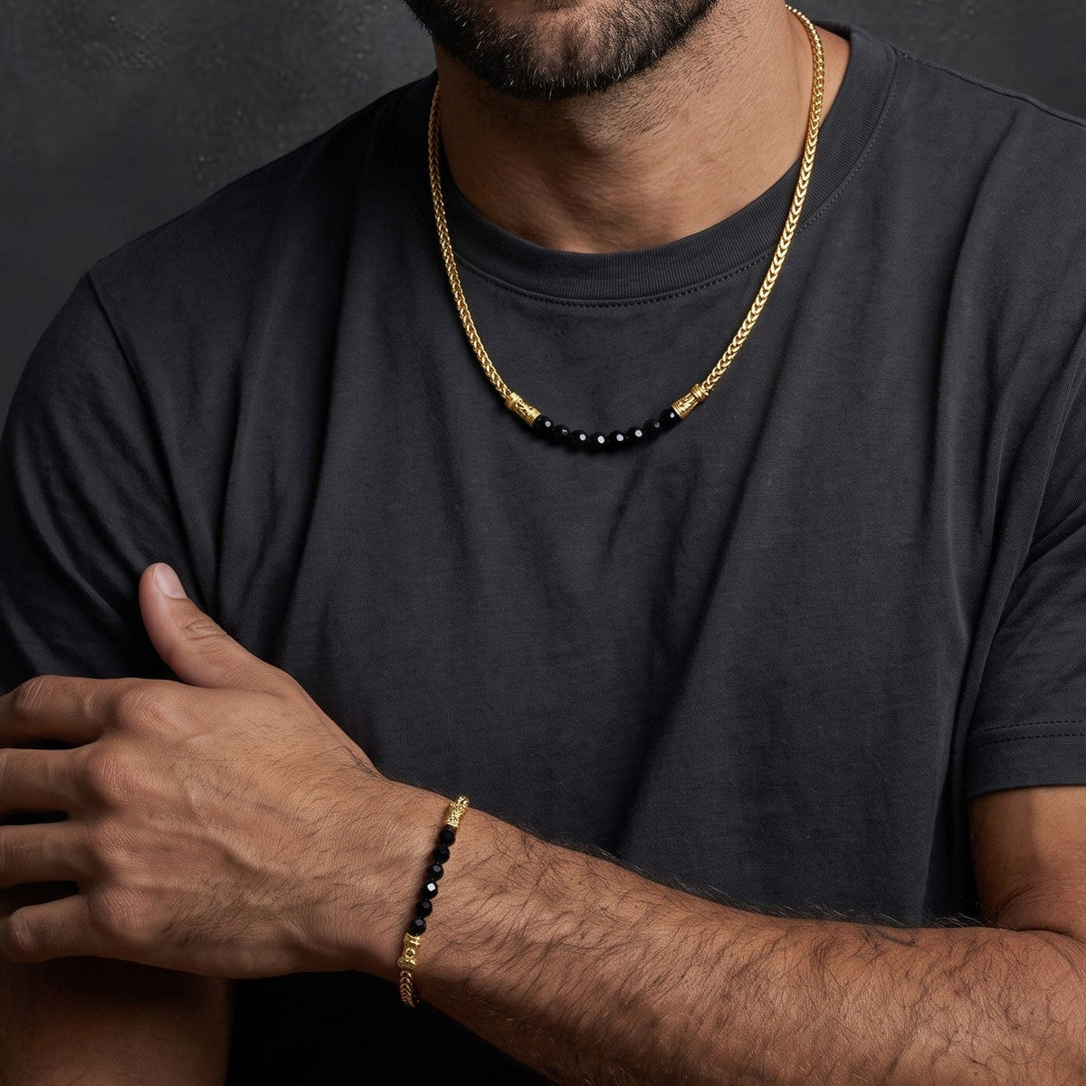 Bruttall CORE gold-plated chain necklace with faceted black Swarovski crystals worn by a man in a grey t-shirt