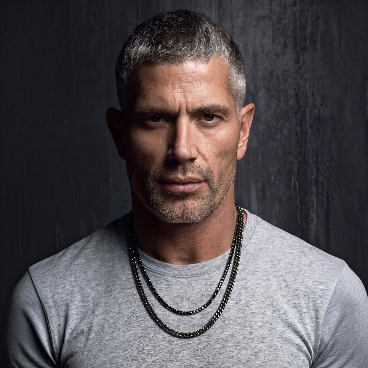 Bruttall GATE necklace featuring an antique black Cuban chain with Swarovski crystals worn by a man in a grey shirt