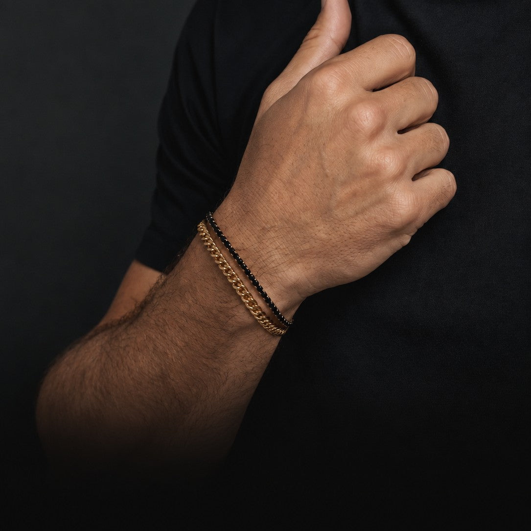 Bruttall GATE bracelet set featuring a gold-plated chain and a black Swarovski crystal strand on a man's wrist.