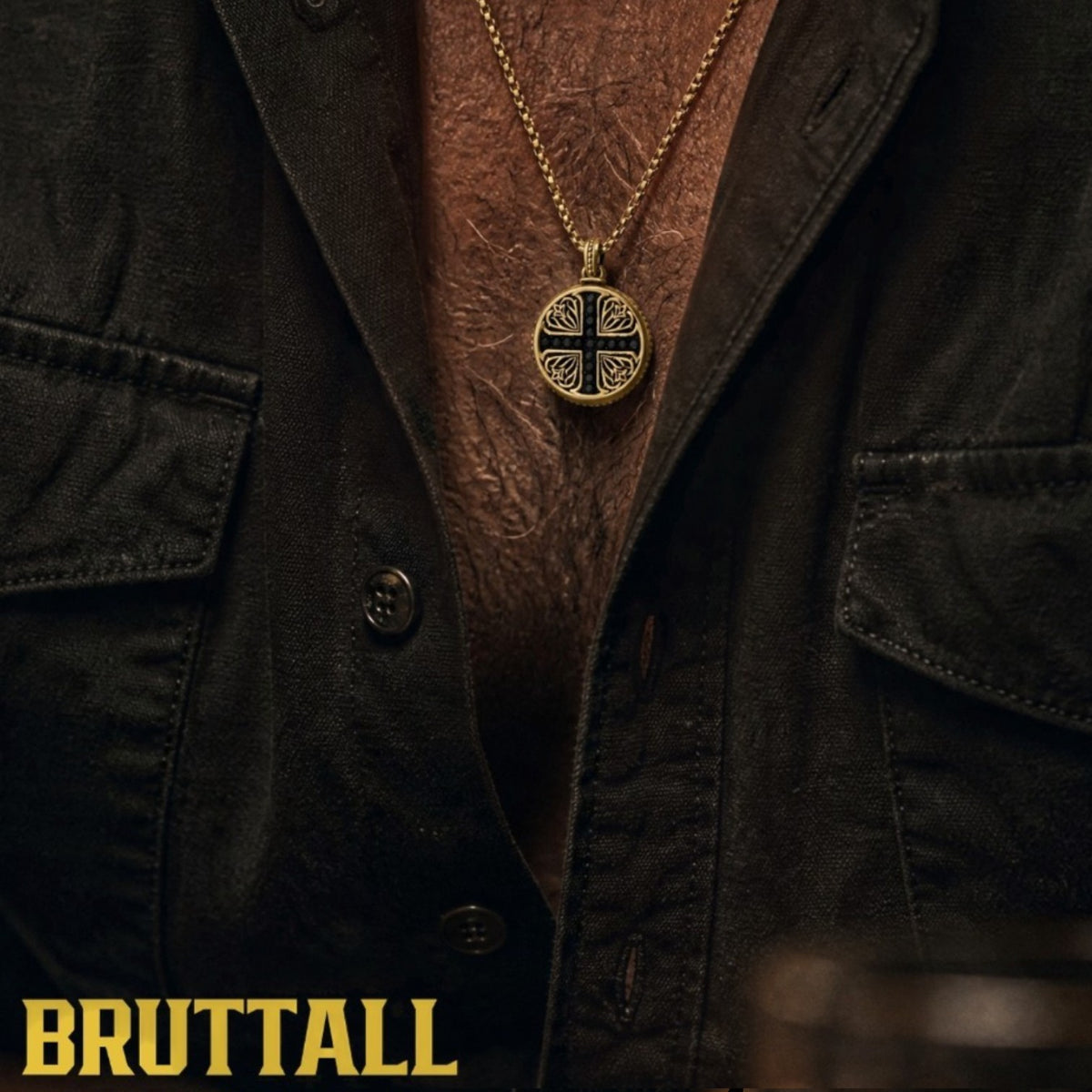 Bruttall GOTHIC necklace in matt gold featuring a round pendant with Swarovski Zirconia on a man in a black shirt