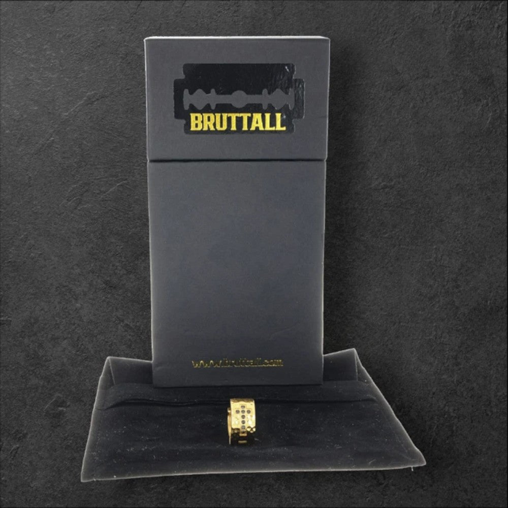 Bruttall RAW cross hoop earring in matte gold with Swarovski Zirconia, displayed in front of a branded black box.