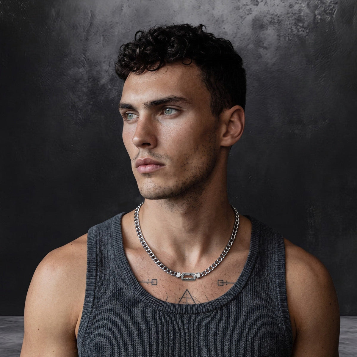 Bruttall AXIS chain in antique black with Swarovski Zirconia, worn by a man in a grey tank top against a dark wall.