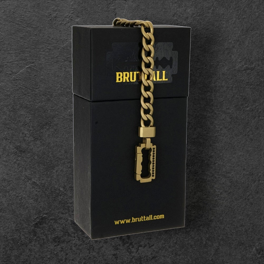 Bruttall AXIS gold-plated chain featuring a razor blade clasp with black Swarovski Zirconia on a black display box.