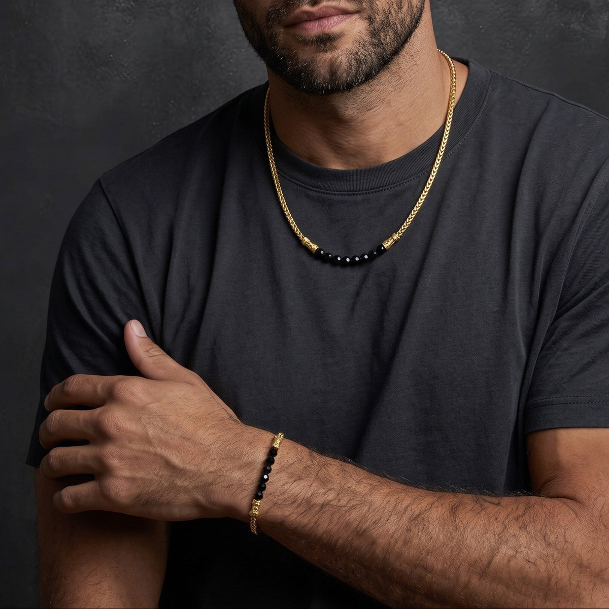 Bruttall CORE bracelet featuring gold plated accents and faceted black Swarovski crystals on a man's wrist