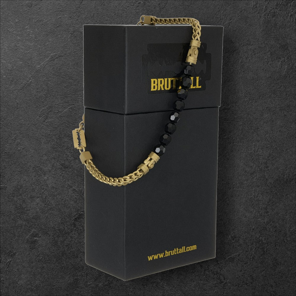 Bruttall CORE gold-plated bracelet featuring faceted black Swarovski crystals on a chain, displayed on a black box.
