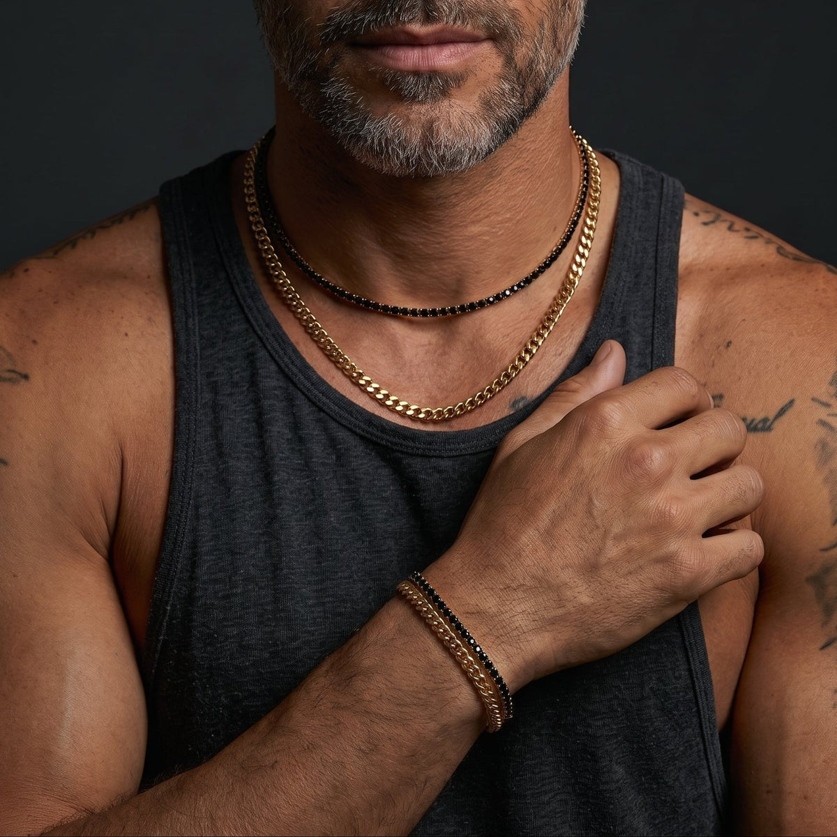 Bruttall GATE gold-plated bracelet with Swarovski crystals worn on a man's wrist alongside matching necklaces