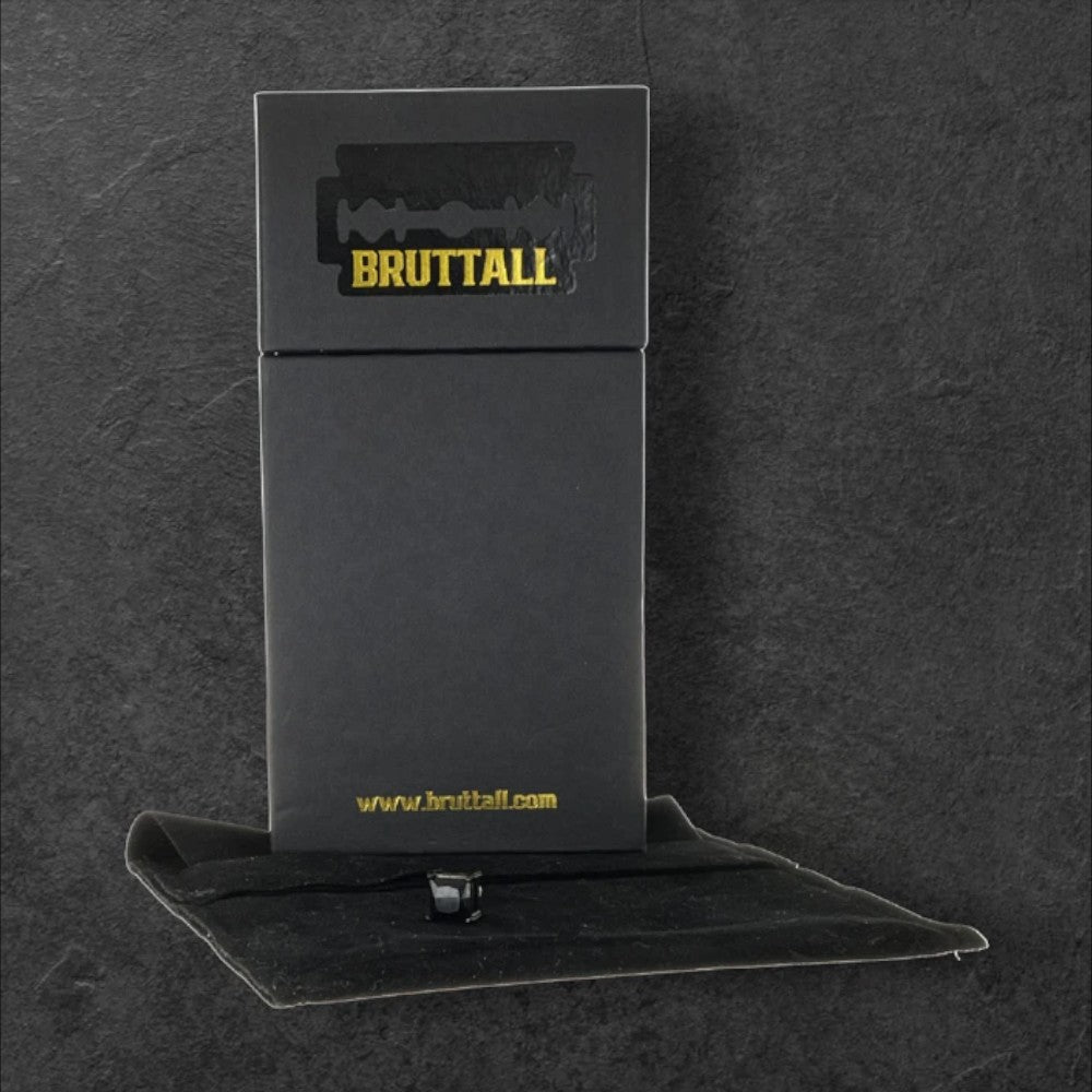 Bruttall square magnetic earring with Swarovski Zirconia in a black branded gift box on a dark textured surface